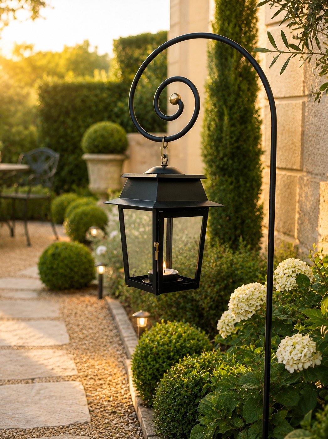 Lanterne de jardin noire sur pied à crosse, allée de jardin à l'heure dorée